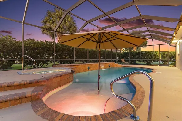a view of swimming pool with seating space and yard in the back