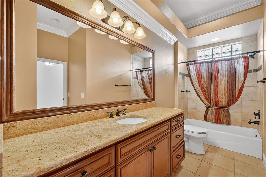 1850 Lake Ridge Drive The Villages, FL 32162 - Photo 51 of 70 a bathroom with a granite countertop sink a toilet a mirror and shower