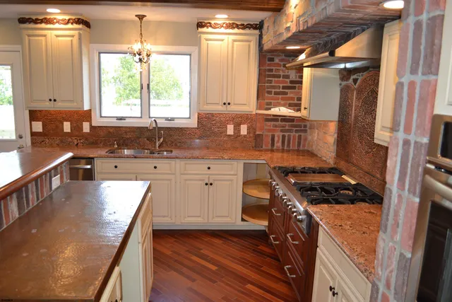 a kitchen with stainless steel appliances granite countertop a sink stove and cabinets