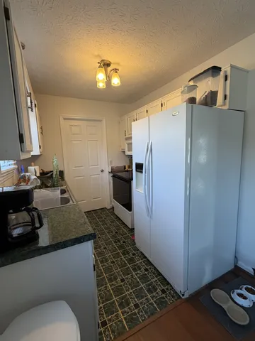 a kitchen with a sink a refrigerator a stove and cabinets