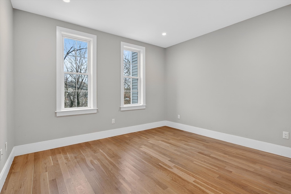 54 River Street, Unit 2 Boston, MA 02126 - Photo 12 of 16 a view of an empty room with wooden floor and a window