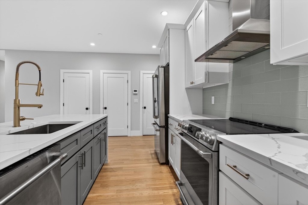 54 River Street, Unit 2 Boston, MA 02126 - Photo 3 of 16 a kitchen with granite countertop a stove and a sink