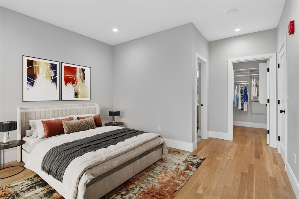 54 River Street, Unit 2 Boston, MA 02126 - Photo 9 of 16 a bedroom with a bed and wooden floor