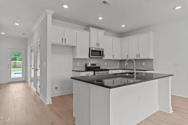 a kitchen with a sink stove and cabinets