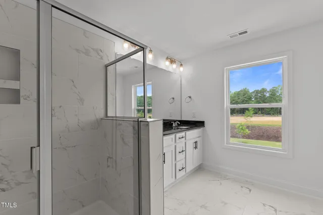 a bathroom with a granite countertop sink mirror and window