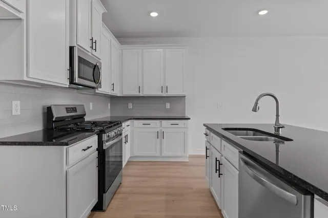 a kitchen with stainless steel appliances granite countertop a stove and a microwave