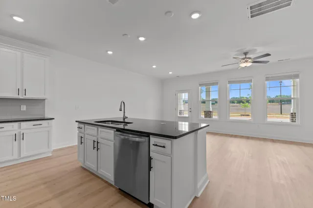 a kitchen with granite countertop a sink and cabinets