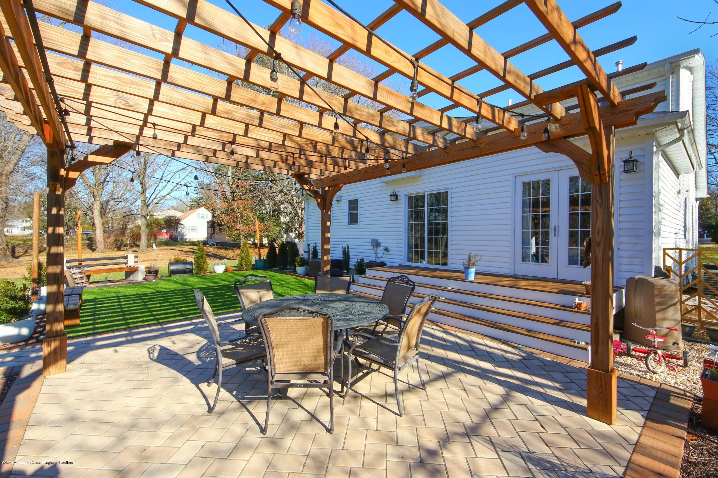 600 E Road Middletown, NJ 07748 - Photo 23 of 23 a view of a patio with a table and chairs under an umbrella