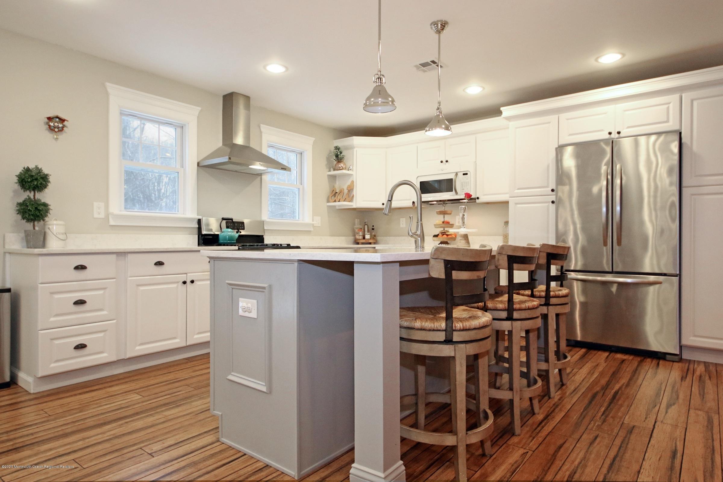 600 E Road Middletown, NJ 07748 - Photo 6 of 23 a kitchen with stainless steel appliances a refrigerator a sink dishwasher a stove and white cabinets with wooden floor