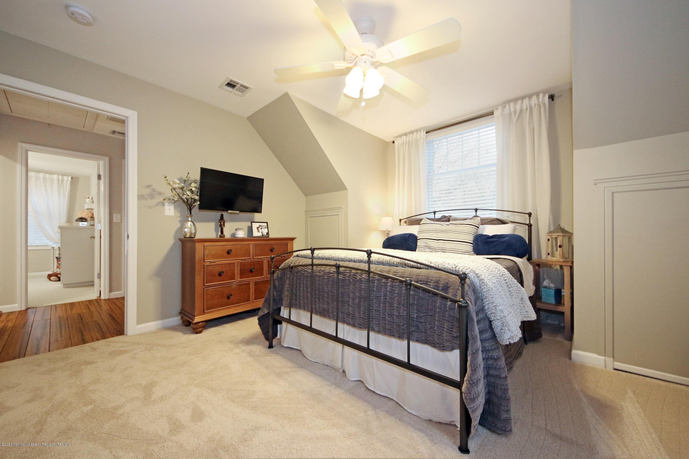 600 E Road Middletown, NJ 07748 - Photo 10 of 23 a bedroom with a bed and a flat tv screen on dresser
