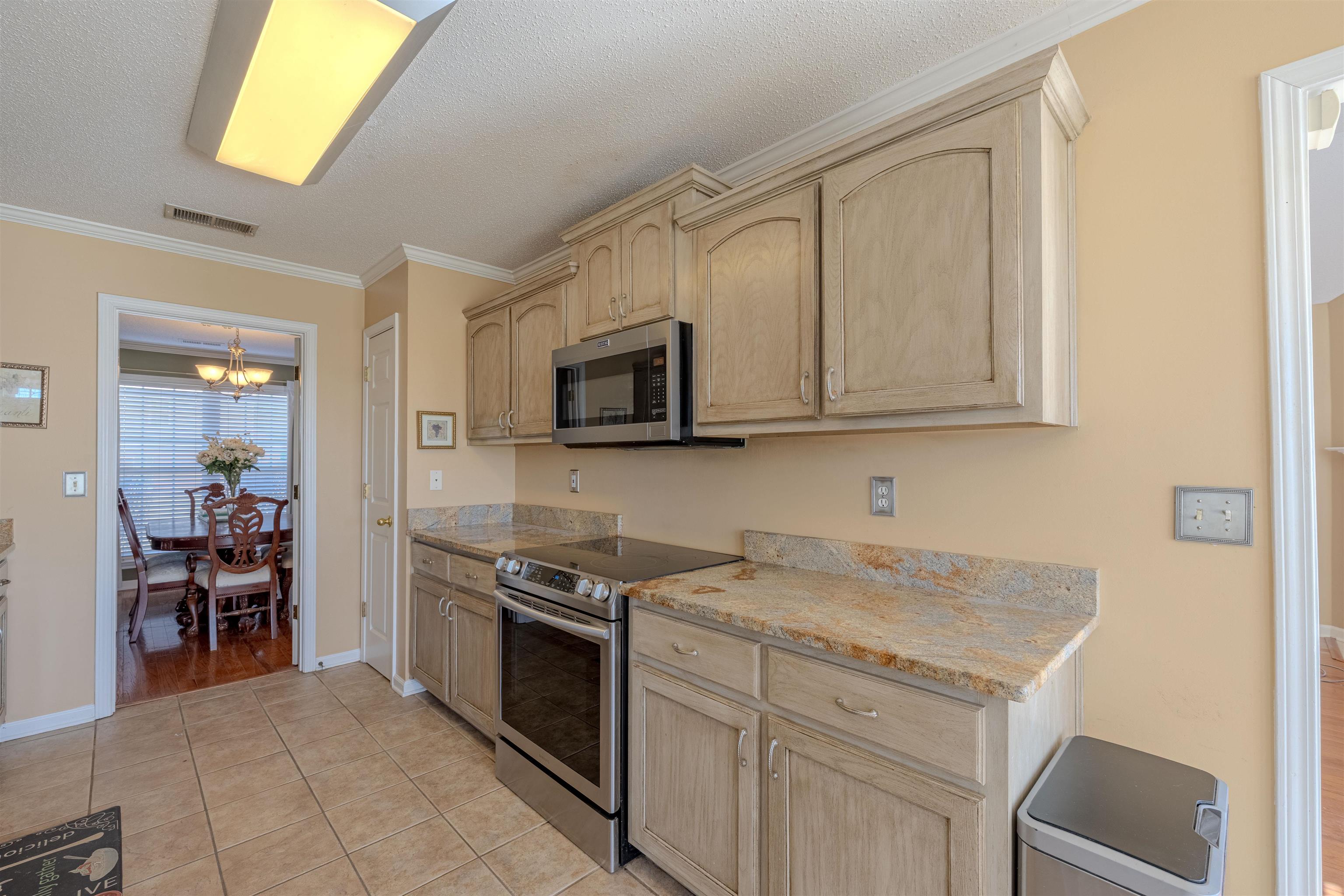 5991 Marley Street Arlington, TN 38002 - Photo 8 of 30 a kitchen with stainless steel appliances granite countertop a stove and a microwave