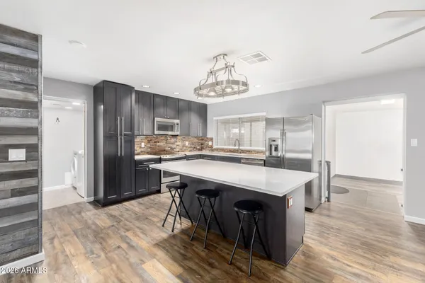 a kitchen with kitchen island a sink counter top space and stainless steel appliances