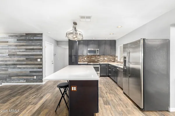 a kitchen with stainless steel appliances a refrigerator sink and stove