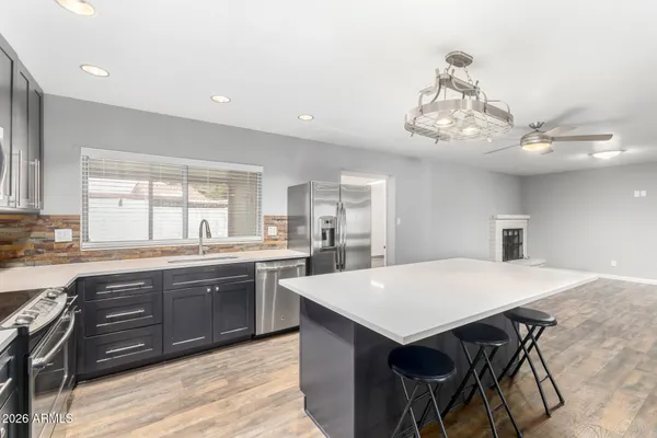 a large kitchen with kitchen island a sink table and chairs