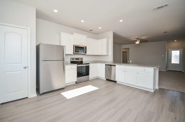 a kitchen with a refrigerator a stove top oven and a sink