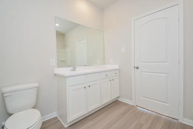 a bathroom with a toilet a sink and mirror