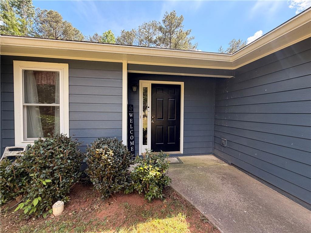 145 Stoneview Circle Covington, GA 30016 - Photo 17 of 41 a view of yellow house with a large window and flower garden