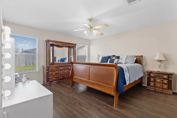 a bedroom with a bed and a dresser with mirror