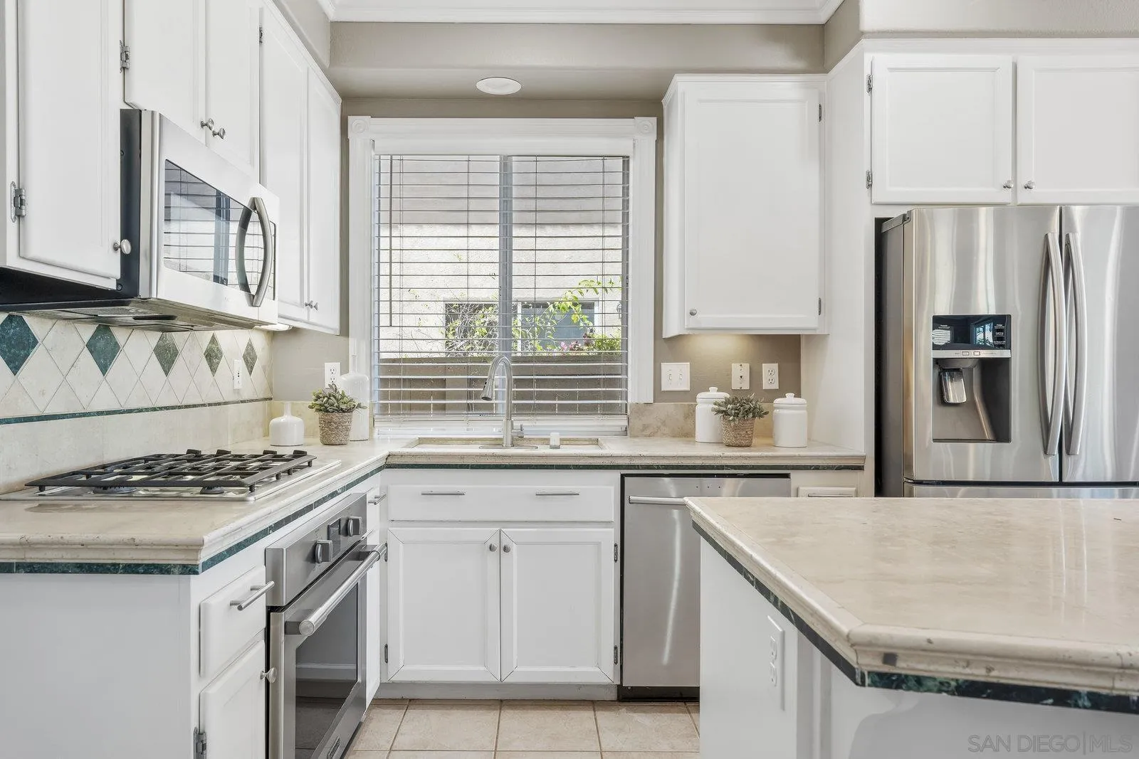 11542 Village Ridge Road San Diego, CA 92131 - Photo 16 of 42 a kitchen with granite countertop a sink stove and refrigerator