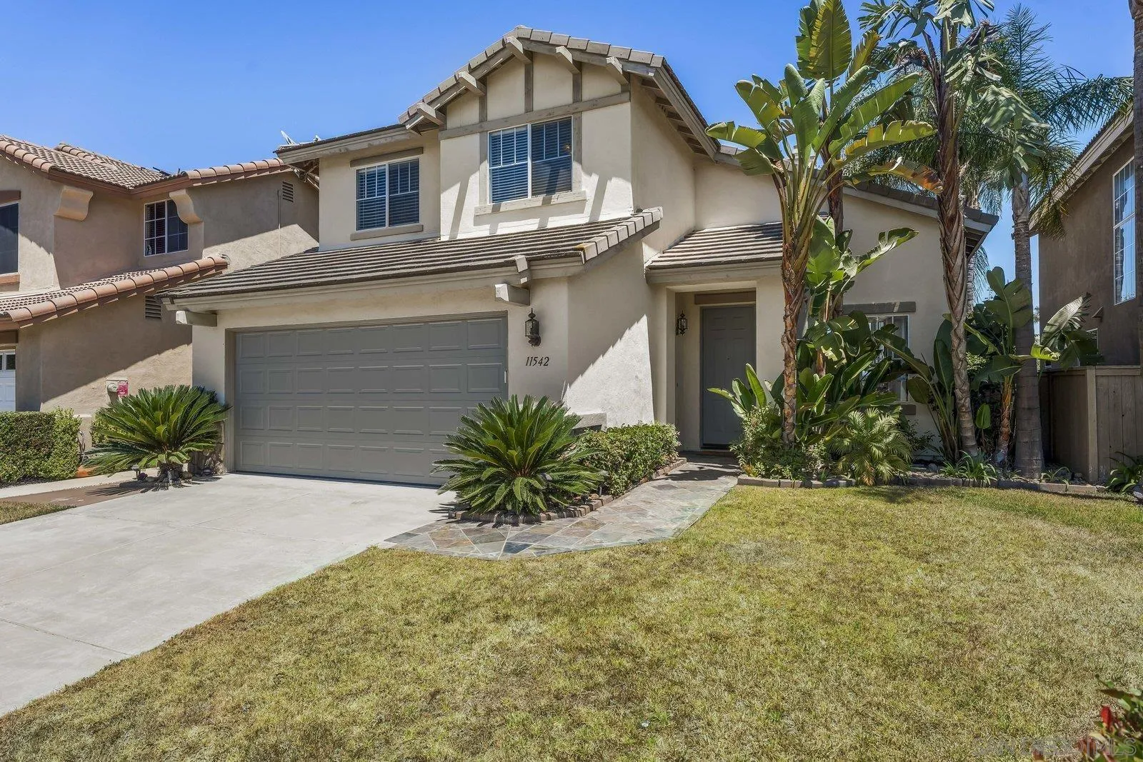 11542 Village Ridge Road San Diego, CA 92131 - Photo 2 of 42 a front view of a house with a yard and garage