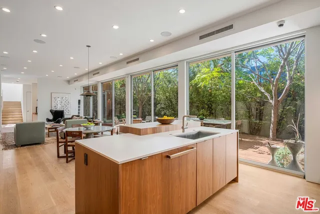 a kitchen with stainless steel appliances a sink a table and chairs