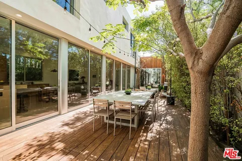 a view of backyard with a table and chairs and wooden fence
