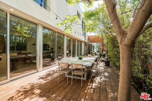 a view of backyard with a table and chairs and wooden fence