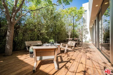 a view of a patio with table and chairs with wooden floor and fence