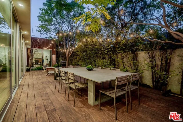 a view of a patio with a table and chairs and couches with wooden floor