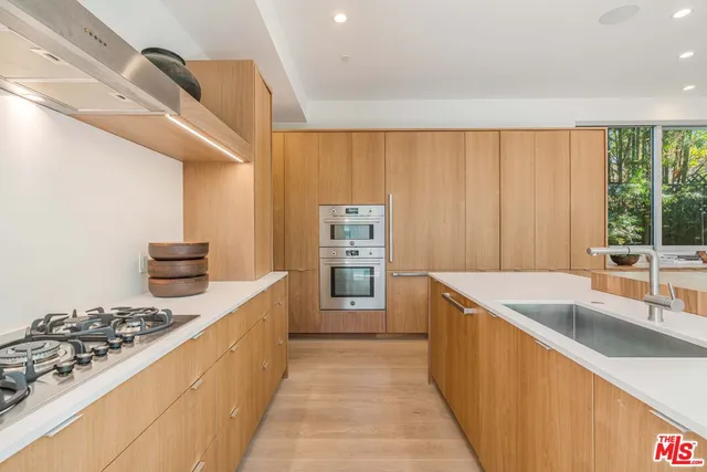 a kitchen with stainless steel appliances granite countertop a sink stove and cabinets