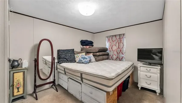 a spacious bedroom with a bed and a flat screen tv