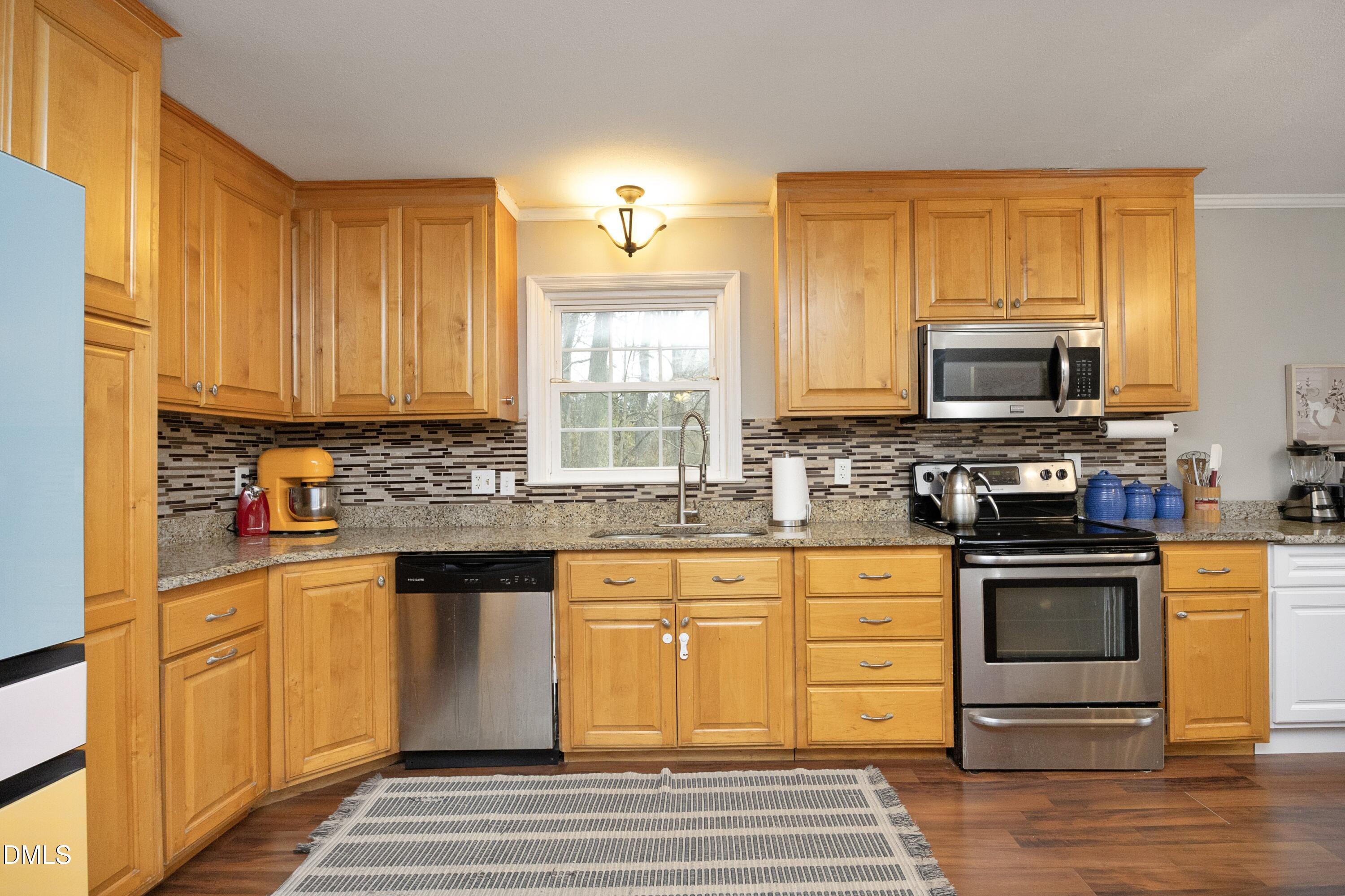 7117 Sunset Lake Road Fuquay-Varina, NC 27526 - Photo 15 of 41 a kitchen with stainless steel appliances granite countertop a stove microwave and cabinets