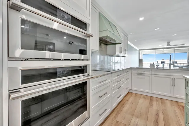 a kitchen with kitchen island granite countertop a sink stainless steel appliances and cabinets