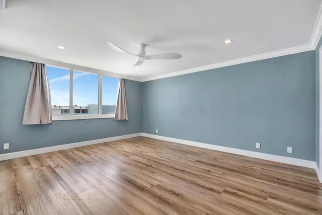 a view of room with wooden floor and fan