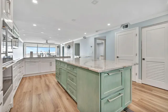 a kitchen with granite countertop white cabinets and appliances