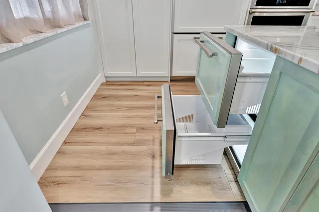 a kitchen with stainless steel appliances kitchen island granite countertop a refrigerator and a stove top oven