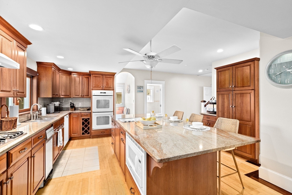 24 Warren Street Hull, MA 02045 - Photo 7 of 41 a kitchen with stainless steel appliances kitchen island granite countertop a table chairs in it and wooden floors