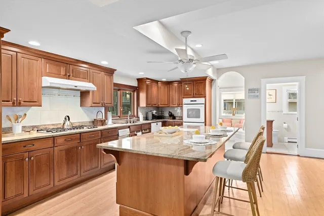 a kitchen with granite countertop a sink a center island and cabinets