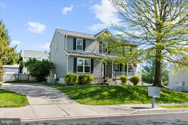 a front view of a house with garden and trees