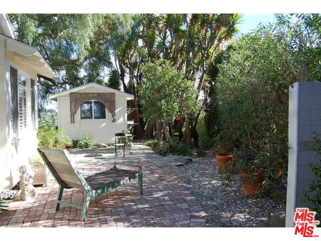 a view of a patio with table and chairs and potted plants