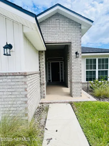 a view of a room with wooden floor fridge and a window