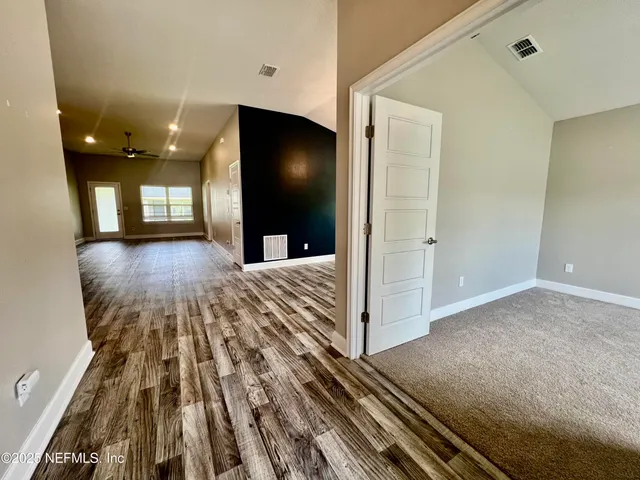 a view of a livingroom with wooden floor and a ceiling fan
