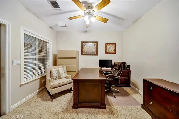 a living room with furniture a flat screen tv and kitchen view