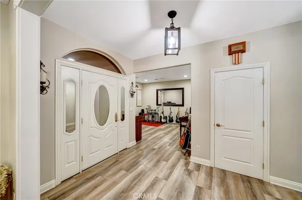 a kitchen with stainless steel appliances granite countertop a stove a refrigerator a sink a stove and white cabinets with wooden floor