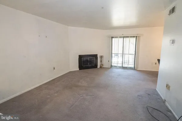 an empty room with a window and a fireplace