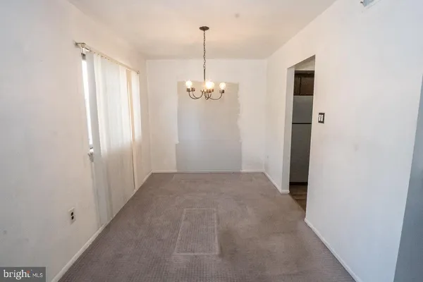 a view of a hallway with chandelier and entryway
