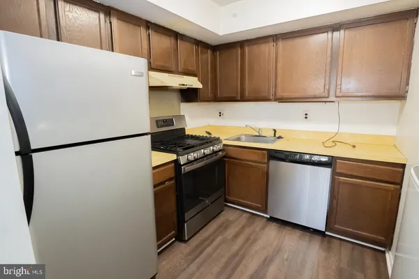 a kitchen with stainless steel appliances a refrigerator sink and cabinets