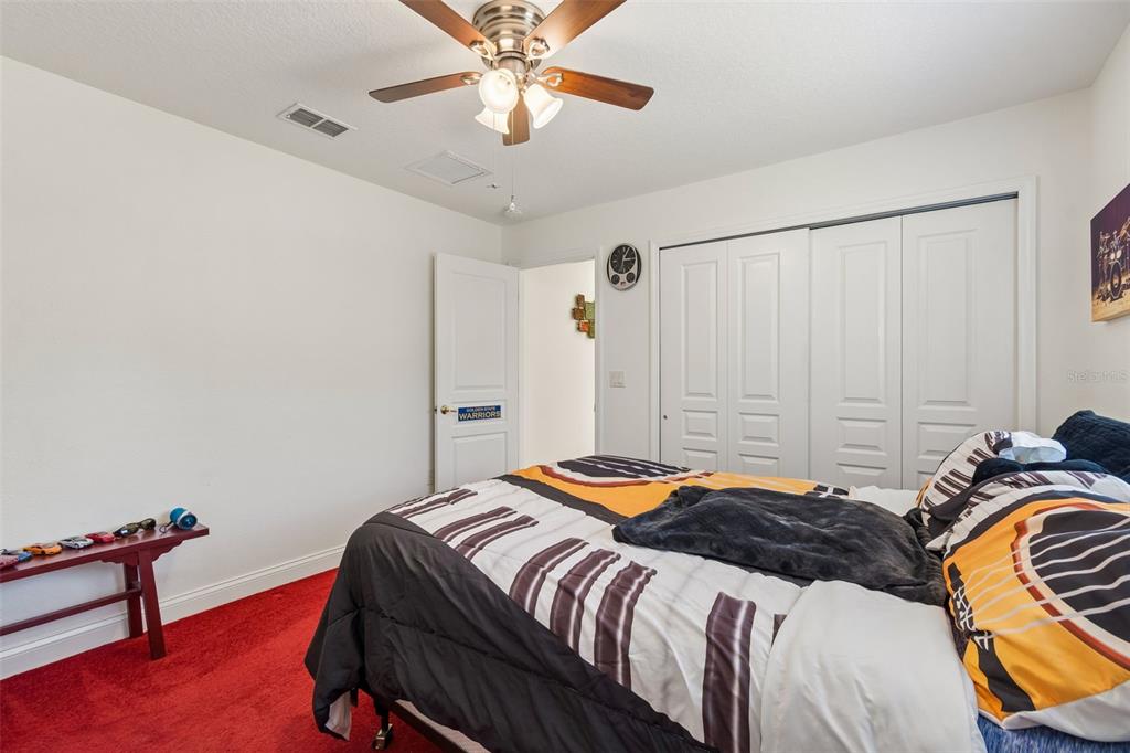 11017 Audie Brook Drive Spring Hill, FL 34608 - Photo 37 of 67 a bedroom with a bed and a chandelier