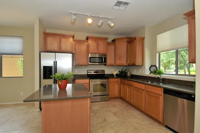 a kitchen with stainless steel appliances granite countertop a sink stove and refrigerator