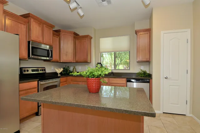 a kitchen with stainless steel appliances granite countertop a sink a stove top oven a counter space and cabinets